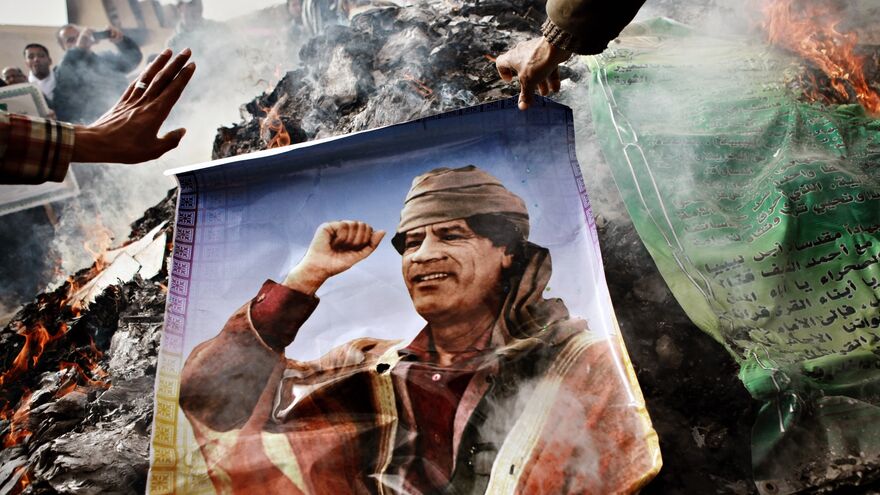 Benghazi residents burn portraits of Muammar Gaddafi, banners with his quotes and his Green Book. Benghazi residents burn portraits of Muammar Gaddafi, banners with his quotes and his Green Book.