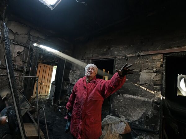 A woman in a burned-out house after shelling